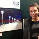 Young boy standing in front of artwork